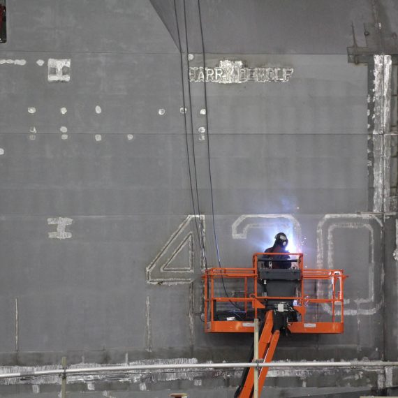 The name and hull number of the future HMCS Harry DeWolf are marked on the ships bow before the mega-block is painted.